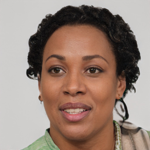 Joyful black adult female with short  brown hair and brown eyes