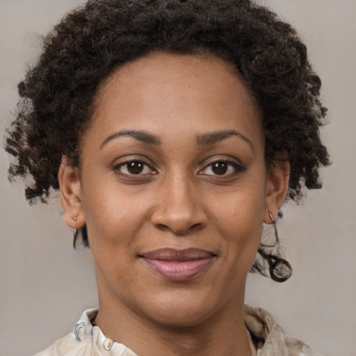 Joyful black adult female with medium  brown hair and brown eyes