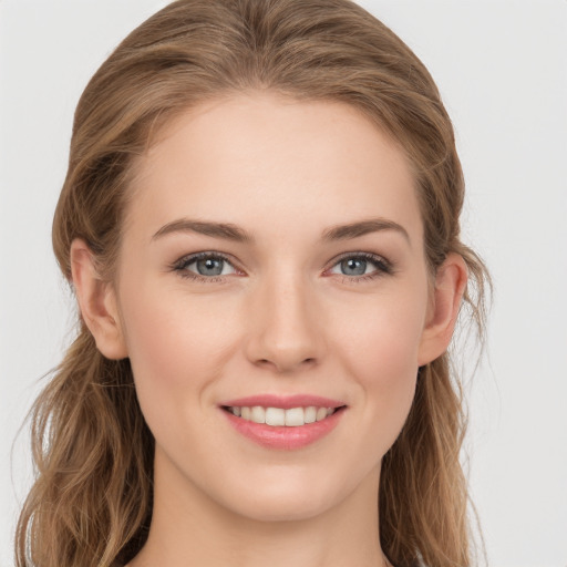 Joyful white young-adult female with long  brown hair and grey eyes