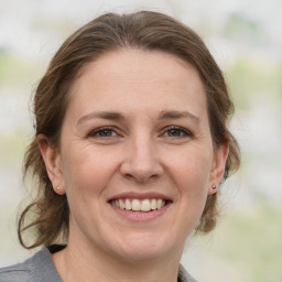 Joyful white adult female with medium  brown hair and grey eyes