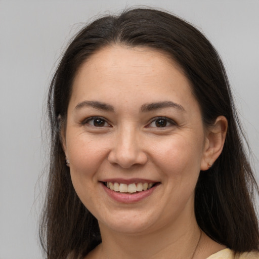 Joyful white young-adult female with long  brown hair and brown eyes