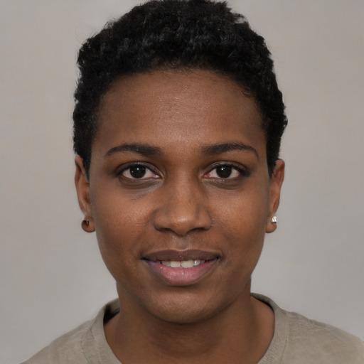Joyful black young-adult female with short  black hair and brown eyes