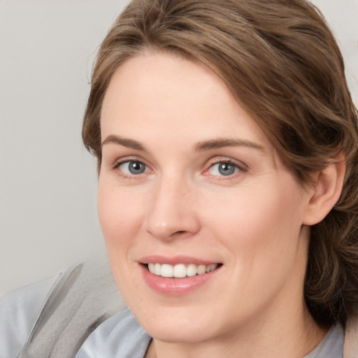 Joyful white young-adult female with medium  brown hair and grey eyes