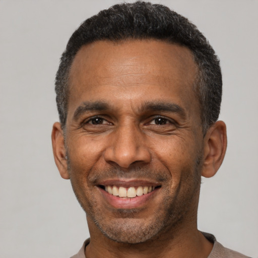 Joyful latino adult male with short  black hair and brown eyes