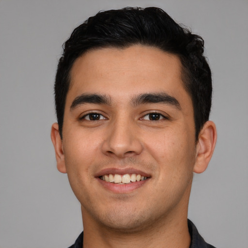 Joyful latino young-adult male with short  black hair and brown eyes