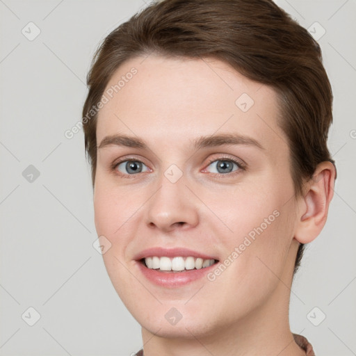 Joyful white young-adult female with short  brown hair and grey eyes