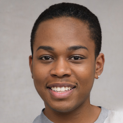 Joyful black young-adult female with short  black hair and brown eyes