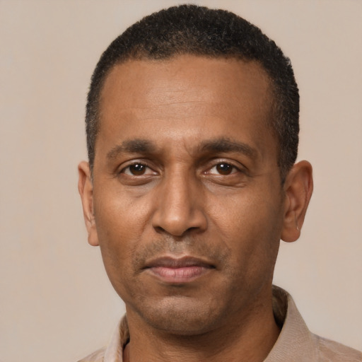 Joyful black adult male with short  black hair and brown eyes