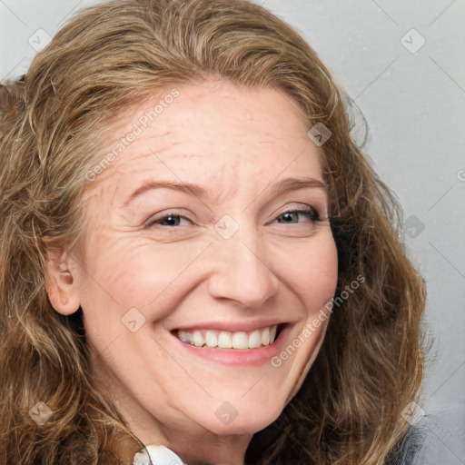 Joyful white adult female with long  brown hair and blue eyes