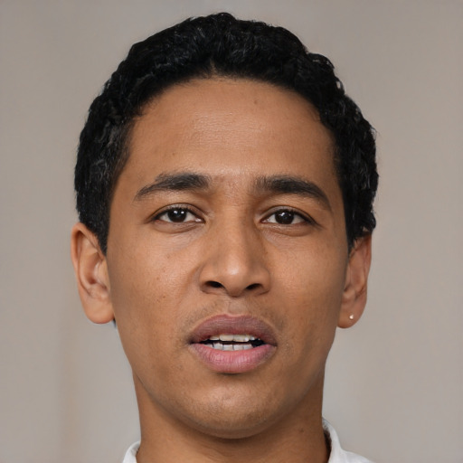 Joyful latino young-adult male with short  black hair and brown eyes