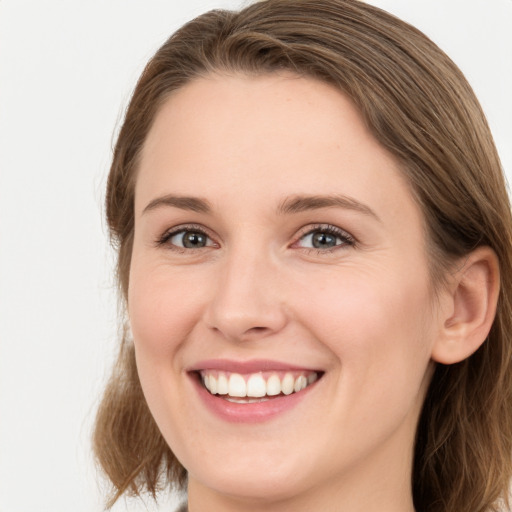 Joyful white young-adult female with long  brown hair and grey eyes