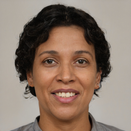 Joyful latino adult female with medium  brown hair and brown eyes