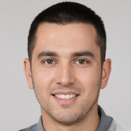 Joyful white young-adult male with short  brown hair and brown eyes