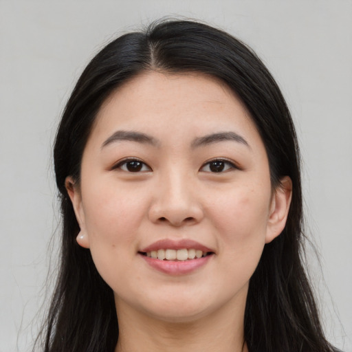 Joyful asian young-adult female with long  black hair and brown eyes