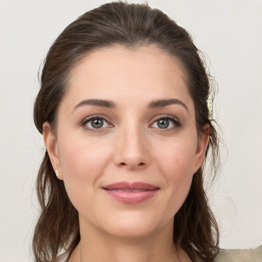 Joyful white young-adult female with medium  brown hair and grey eyes