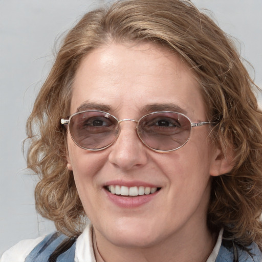 Joyful white adult female with medium  brown hair and blue eyes