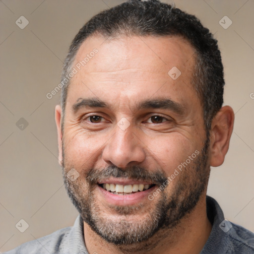 Joyful white adult male with short  black hair and brown eyes