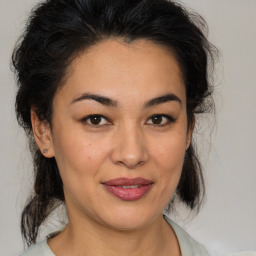 Joyful latino young-adult female with medium  brown hair and brown eyes