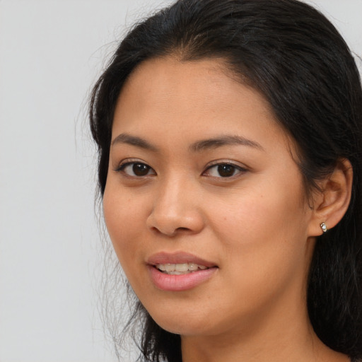Joyful asian young-adult female with long  brown hair and brown eyes