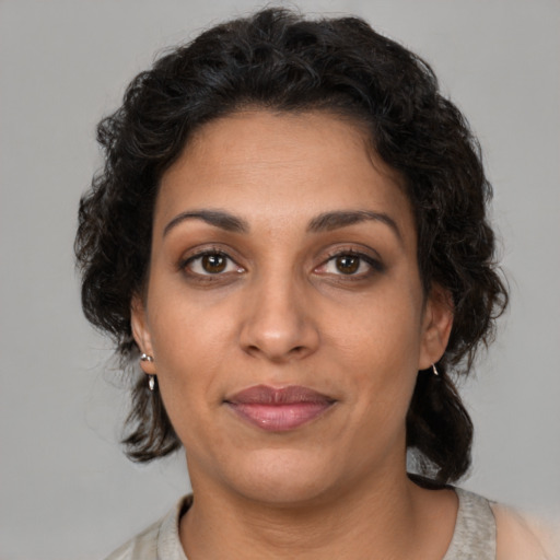 Joyful latino adult female with medium  brown hair and brown eyes