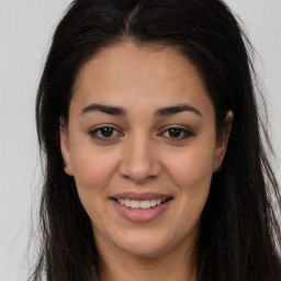 Joyful latino young-adult female with long  brown hair and brown eyes