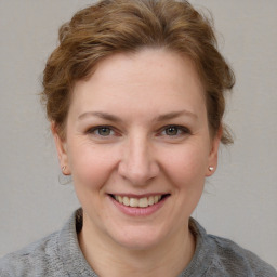 Joyful white young-adult female with short  brown hair and blue eyes