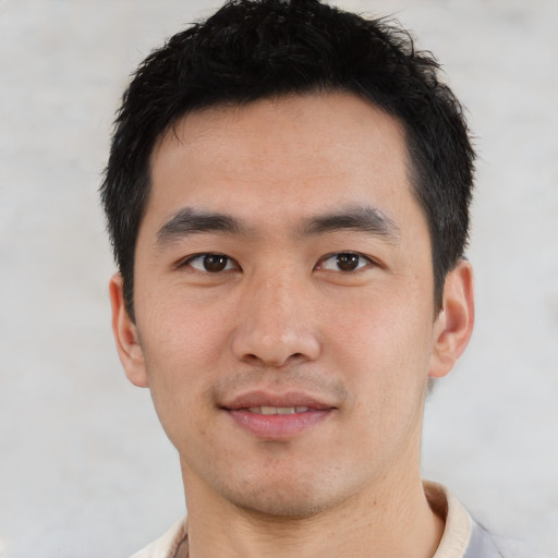 Joyful asian young-adult male with short  brown hair and brown eyes