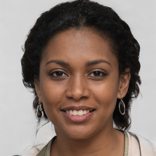 Joyful black young-adult female with long  black hair and brown eyes
