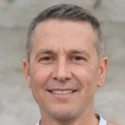 Joyful white adult male with short  brown hair and brown eyes