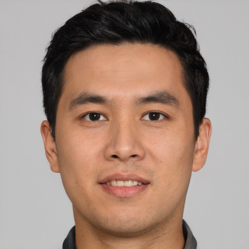 Joyful asian young-adult male with short  black hair and brown eyes