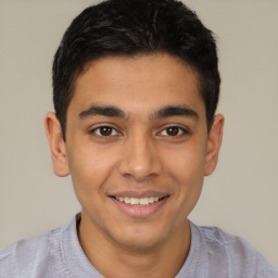 Joyful latino young-adult male with short  brown hair and brown eyes