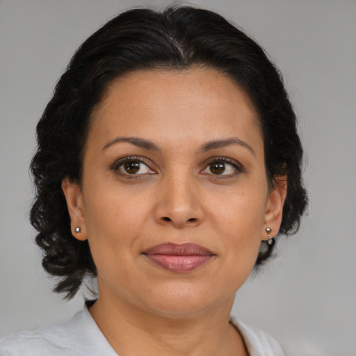 Joyful latino adult female with medium  brown hair and brown eyes