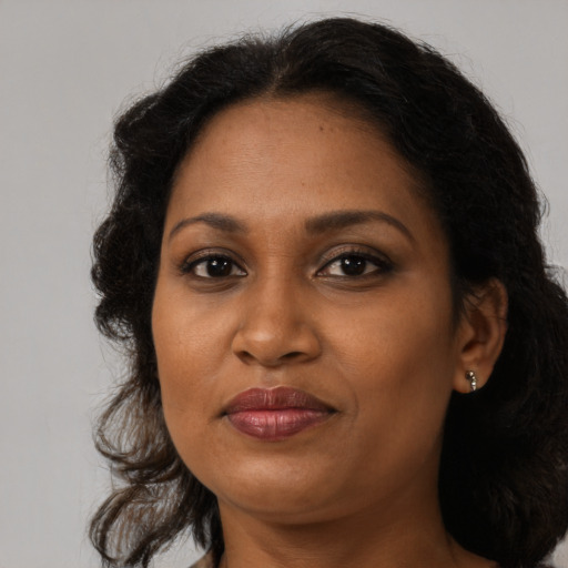Joyful black adult female with medium  brown hair and brown eyes