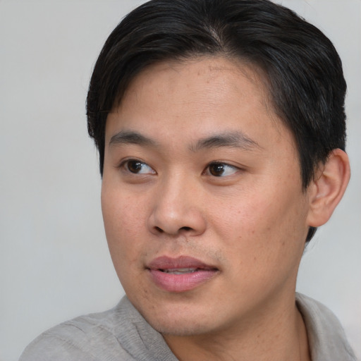 Joyful asian young-adult male with short  black hair and brown eyes