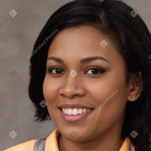 Joyful black young-adult female with long  black hair and brown eyes