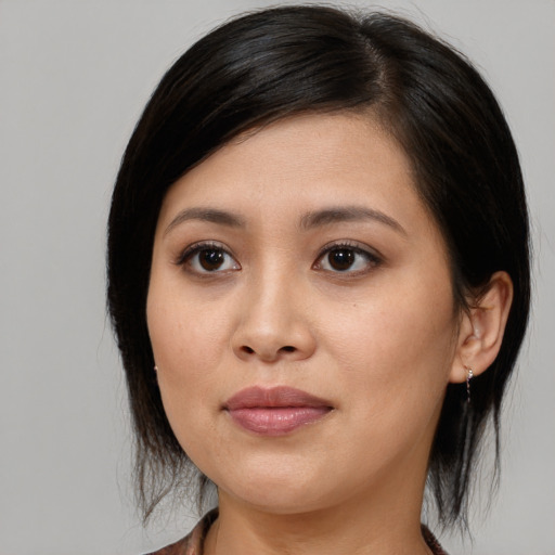 Joyful asian young-adult female with medium  brown hair and brown eyes