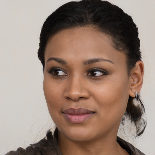 Joyful black young-adult female with medium  brown hair and brown eyes