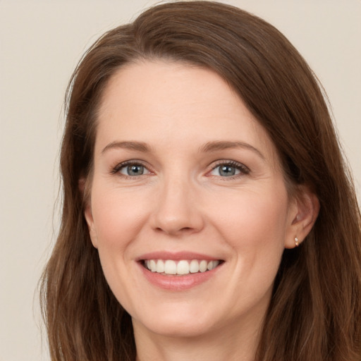 Joyful white young-adult female with long  brown hair and grey eyes