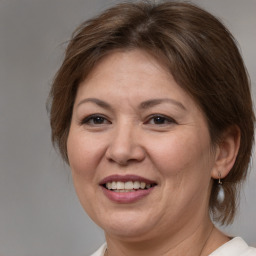 Joyful white adult female with medium  brown hair and brown eyes