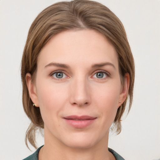 Joyful white young-adult female with medium  brown hair and grey eyes