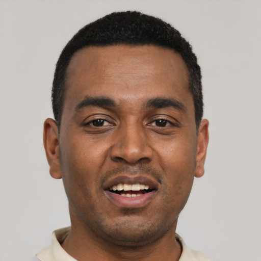 Joyful black young-adult male with short  black hair and brown eyes