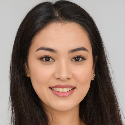 Joyful asian young-adult female with long  brown hair and brown eyes