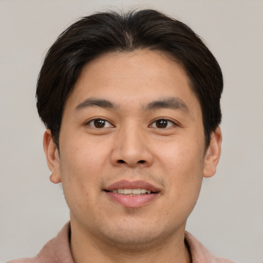 Joyful asian young-adult male with short  brown hair and brown eyes