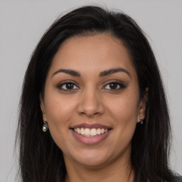 Joyful latino young-adult female with long  brown hair and brown eyes