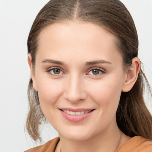 Joyful white young-adult female with long  brown hair and brown eyes