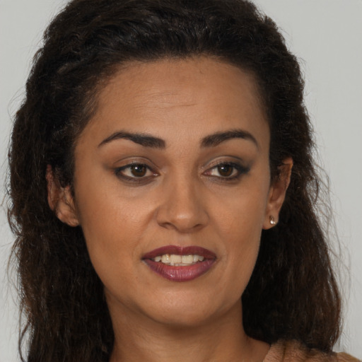 Joyful latino young-adult female with long  brown hair and brown eyes
