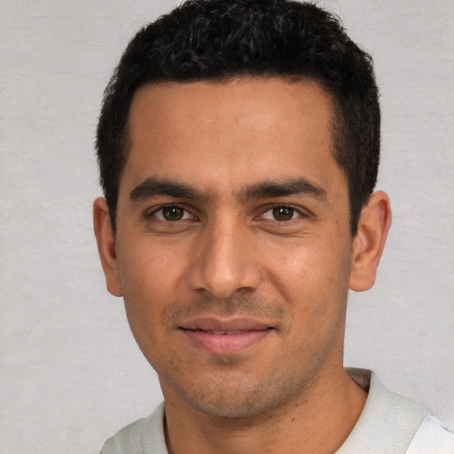 Joyful white young-adult male with short  black hair and brown eyes