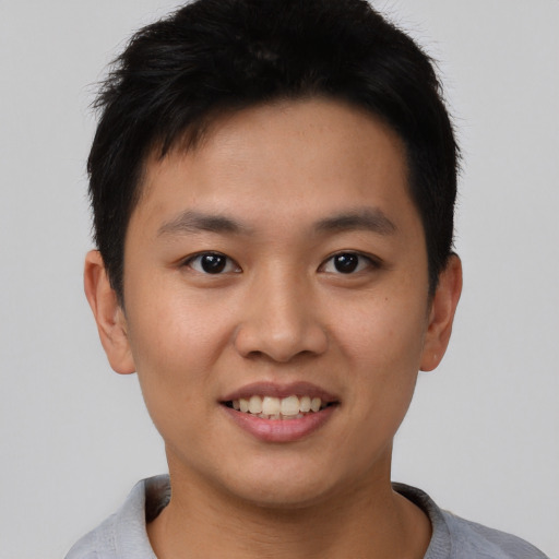 Joyful asian young-adult male with short  black hair and brown eyes