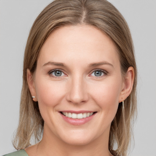 Joyful white young-adult female with medium  brown hair and grey eyes