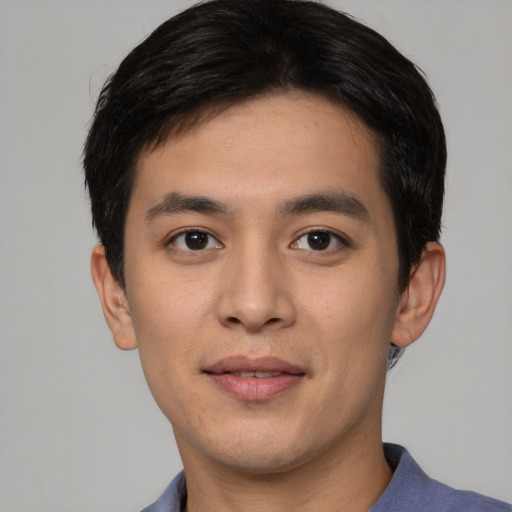 Joyful asian young-adult male with short  black hair and brown eyes